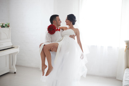 A young bride and groom looking lovingly into each others' eyesの写真素材