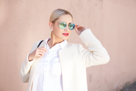 Young fashion beautiful woman in sunglasses on a city streetの写真素材