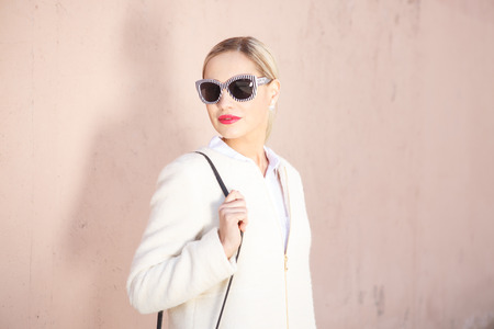 Young fashion beautiful woman in sunglasses on a city streetの写真素材