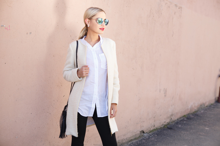 Young fashion beautiful woman in sunglasses on a city streetの写真素材