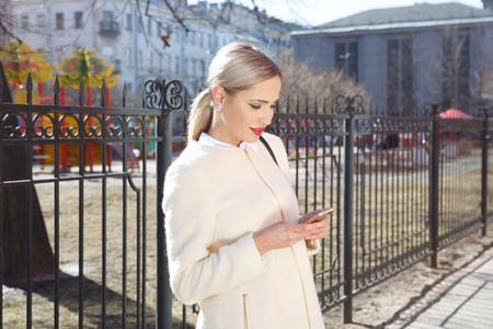 Young fashion beautiful woman in coat on a city streetの写真素材