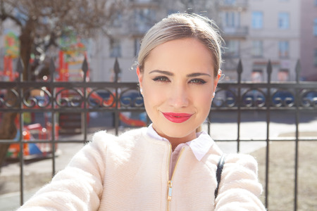 Young fashion beautiful woman in sunglasses on a city street. Selfieの写真素材