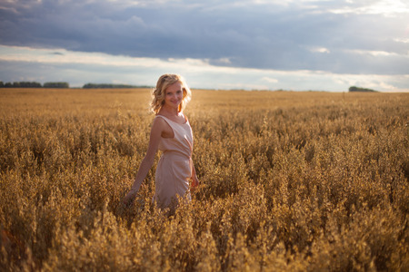 young woman in wheat fieldの写真素材