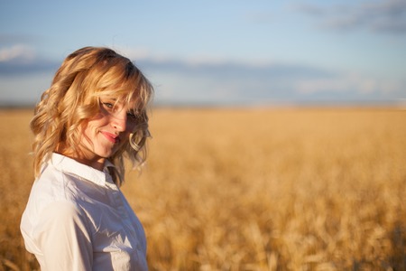 woman in wheat field at sunsetの写真素材