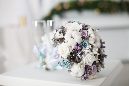 Winter wedding bouquet. Wedding bouquet of flowers lying on a chair near the lovely blue mittens.の写真素材