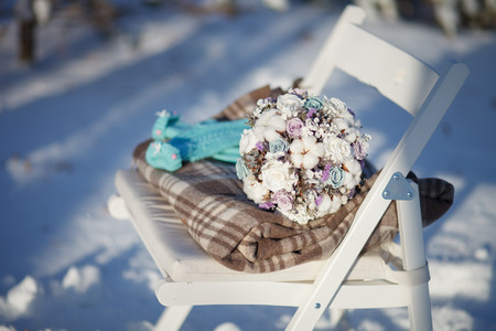 Wedding bouquet lying on the rug on the chair in the winter sunny day in the park.の写真素材