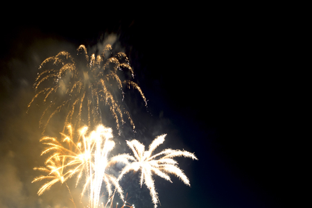 Beautiful colorful holiday fireworks in the evening sky with majestic clouds,  long exposureの写真素材