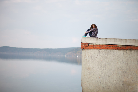 Girl on the background of the lake. Sunset or sunrise.の写真素材