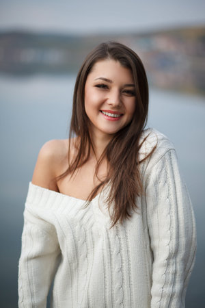Beautiful woman  near mountain lake. . On the background of the sea. Sunset lightの写真素材