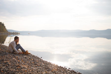 Beautiful young woman looked with delight at the sea and sky on sunsetの写真素材