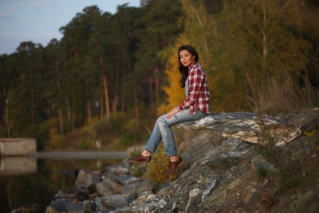 Young woman  sitting by the lake in the woodsの写真素材