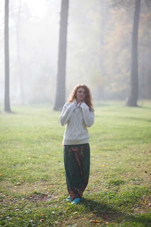 Young girl dancing in the forest. Sun rays beating down on woman walking in forestの写真素材