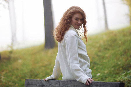 Beautiful woman wearing sweater in autumn parkの写真素材