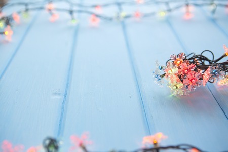 wood board table in front of Christmas warm gold garland lights on wooden rustic background.の写真素材