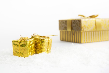 Decorated Christmas gifts in snow on white backgroundの写真素材