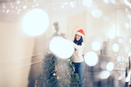 Beautiful Christmas. Bright picture of woman decorating christmas treeの写真素材