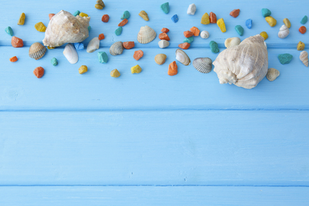Spa stones  on table on light background and a large sea shell. Pile of stones on a blue smooth wooden tableの写真素材