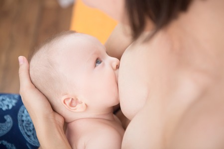 Mother is breast-feeding a newborn baby. Little baby boy breast feedingの写真素材