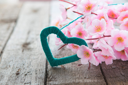 Flowering branch with pink delicate flowers on wooden surface. Declaration of love, spring. Wedding card, Valentine's Day greeting. Wedding bouquet, background.の写真素材