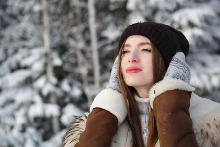 Young woman in winter. Winter woman in snow looking up on snowing cold winter day.