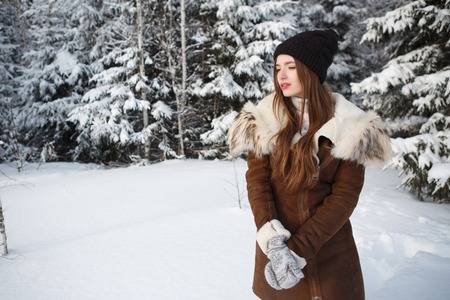 Winter woman on snowing cold winter day. Young woman in winterの写真素材
