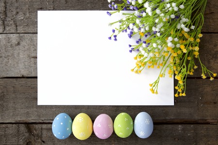 Colorful Easter eggs decoration line over the brown wooden surface as a copyspace festive background compositionの写真素材