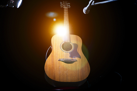 Acoustic wooden a guitar over black background.の写真素材