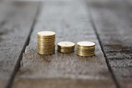 Gold money coins pile on wooden tableの写真素材