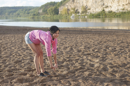 Happy sports woman smiling at the beachの写真素材