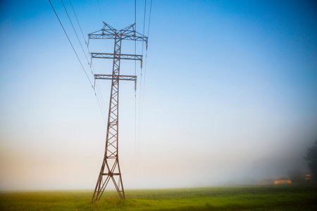 High voltage pole with light early morning fog