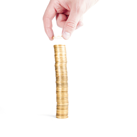 stack gold coins with reflection and hand with coin isolated on whiteの写真素材