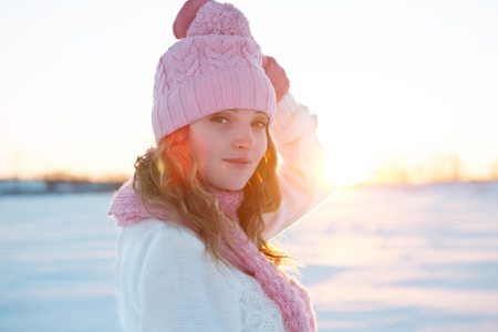Emotive portrait of a fashionable model in white standing at the winter field. Sunny weather. Outdoor shot.の写真素材