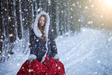 Beautiful girl in winter forest. Fairy tale. Snowfall. Christmas.の写真素材