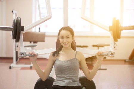 Woman working out on a fitness equipment at the gymの写真素材
