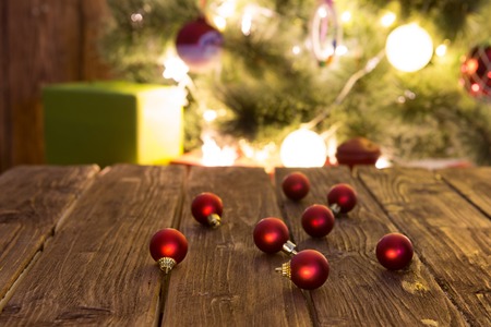 Christmas holiday background with xmas tree lights, gifts and red christmas bals on empty rustic tableの写真素材