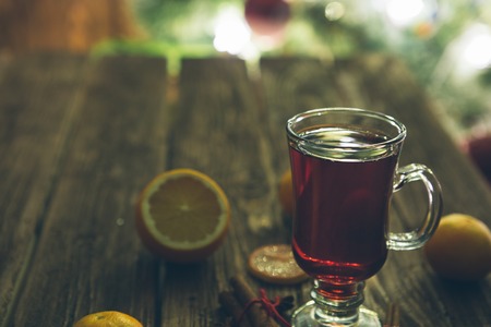 Christmas mulled wine with spices and fruits on dark wooden tableの写真素材