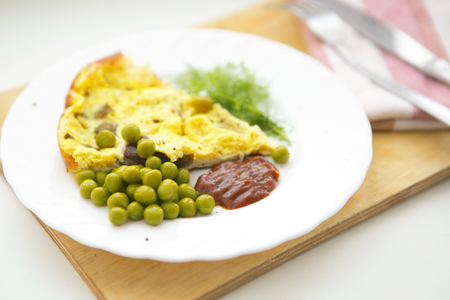 scrambled eggs with green peas and dill on tableの写真素材