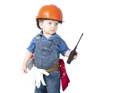 Cute little boy in an orange helmet and tools on white backgroundの写真素材