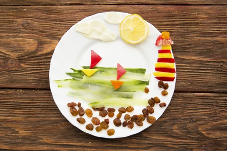Healthy lifestyle concept - vegetable Ships and lighthouse on dish on woodenの写真素材