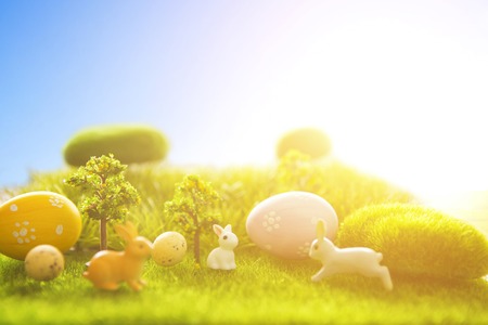 Decorated easter eggs with easter rabbit on grass over sky background. Happy Easter.の写真素材