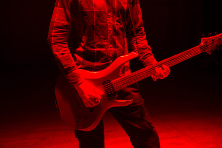 Hands of man playing electric guitar in red light. Bend technique.の写真素材