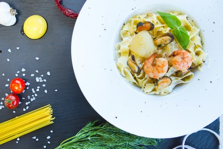 Pasta with seafood on a black stone table. Top view.の写真素材