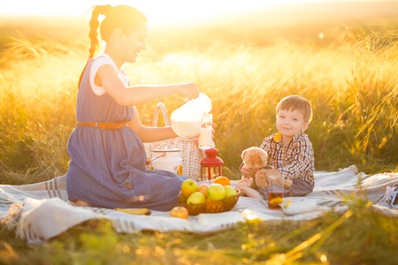 Happy family. Pregnant mother and little son on a picnic. The concept of lifestyle and childhood. Happy family and healthy eating conceptの写真素材