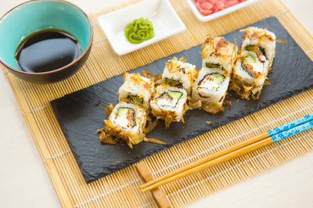 Sushi rolls on black slate surface. Japanese food. Set of sushi and maki on stone table.の写真素材
