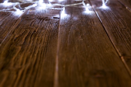 Glowing bokeh background with empty wooden table. Christmas background.の写真素材