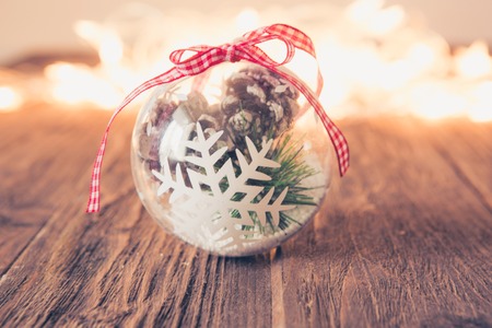 Christmas glass ball on wooden table with defocused christmas lights.の写真素材