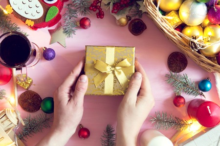 View from above on man holding gift on the Christmas decotated wooden table.の写真素材