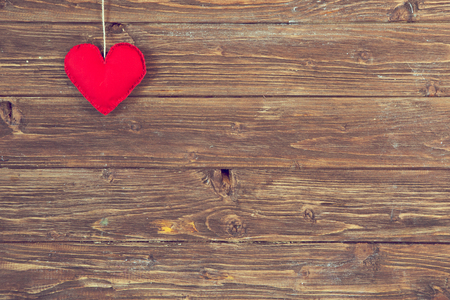 One red heart on line over old wooden wall.の写真素材
