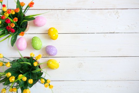 Easter eggs with flowers on white wooden background.の写真素材