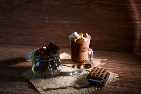 Chocolate cocktail with marshmallows on wooden background.
